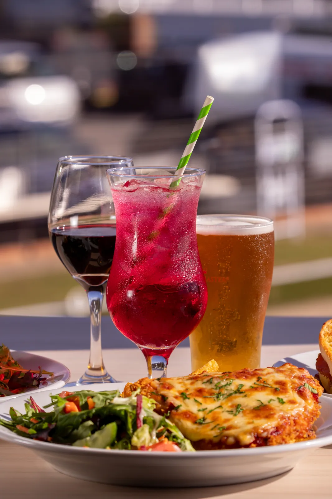 Beef lasagne with a garden salad, a beer and a mocktail, served on the deck overlooking the green